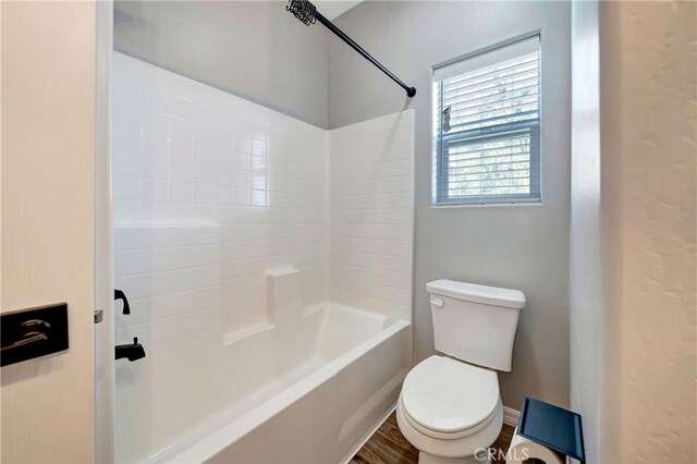 bathroom with wood-type flooring, toilet, and shower / washtub combination