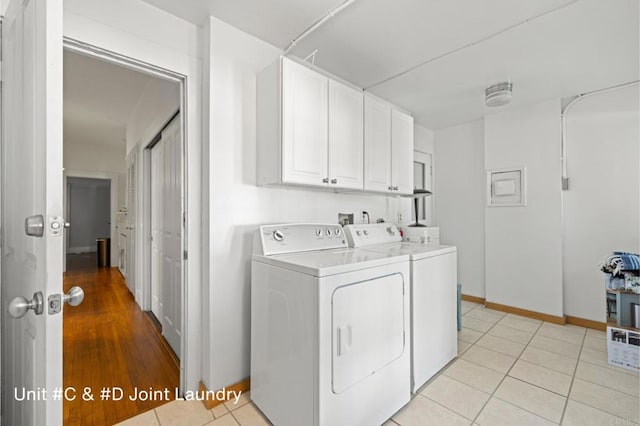 washroom featuring cabinet space, washer and clothes dryer, baseboards, and light tile patterned floors