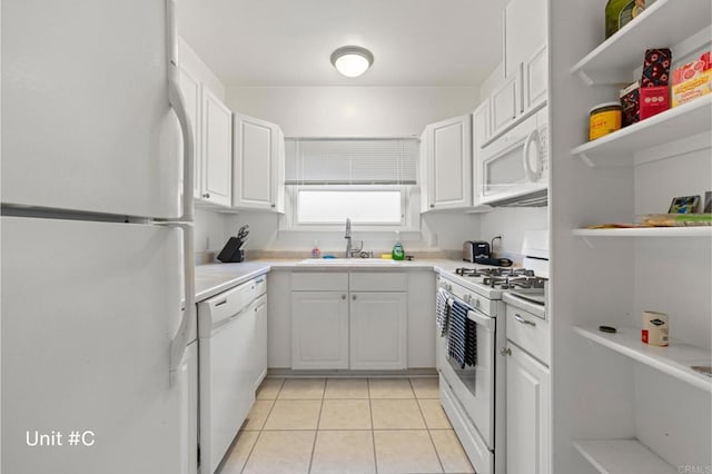 kitchen featuring light tile patterned floors, white appliances, a sink, white cabinetry, and light countertops