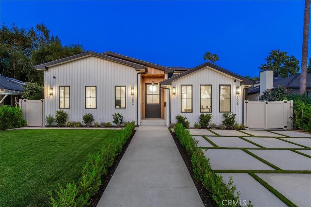 modern farmhouse style home with a front lawn