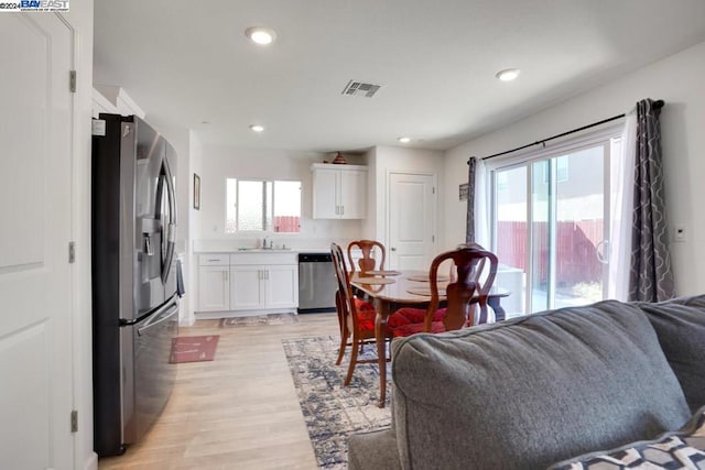 dining room featuring a wealth of natural light, light wood-type flooring, and sink