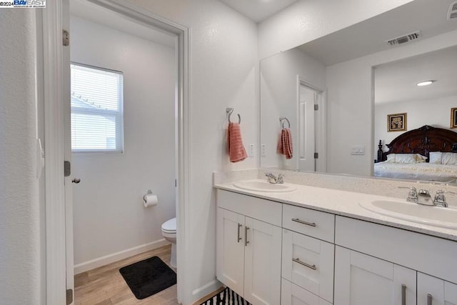 bathroom with hardwood / wood-style floors, vanity, and toilet