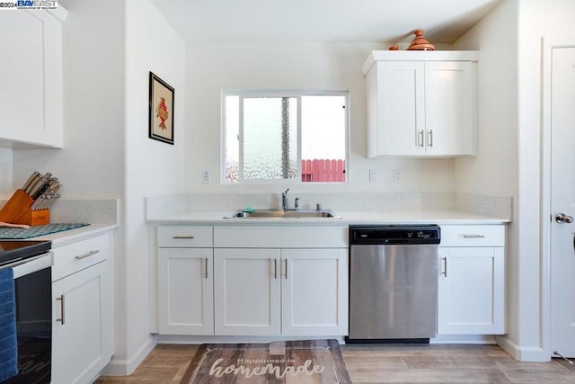 kitchen featuring stainless steel appliances, white cabinets, light wood-type flooring, and sink