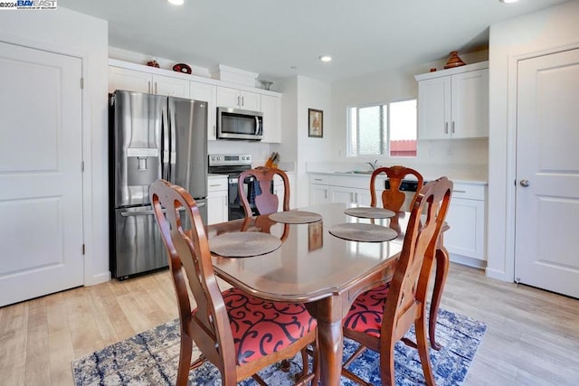 dining area with light wood-type flooring and sink