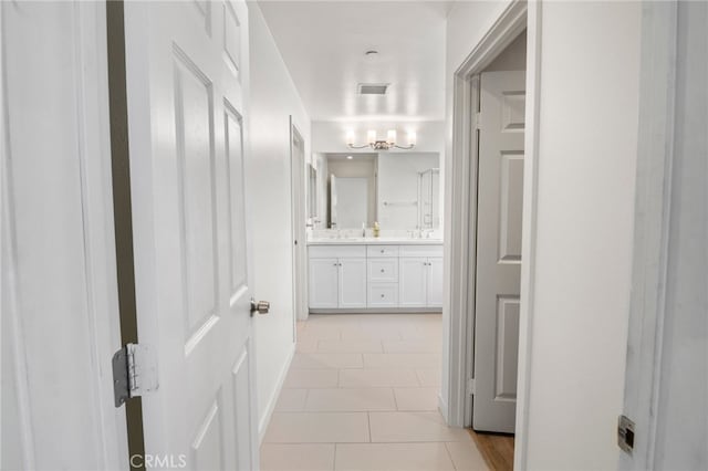 corridor with light tile patterned flooring and sink