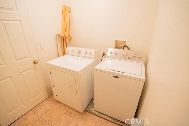 laundry room with washer and clothes dryer and light tile patterned floors