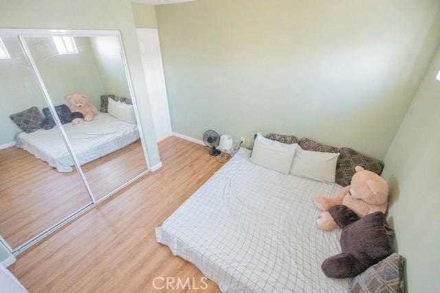 bedroom featuring wood-type flooring and a closet