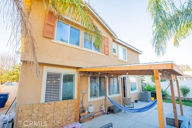 rear view of property featuring central AC and a patio area