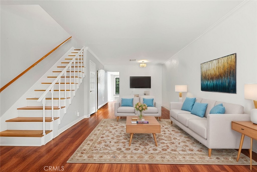 living room with wood-type flooring and crown molding