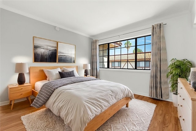 bedroom featuring crown molding and light wood-type flooring