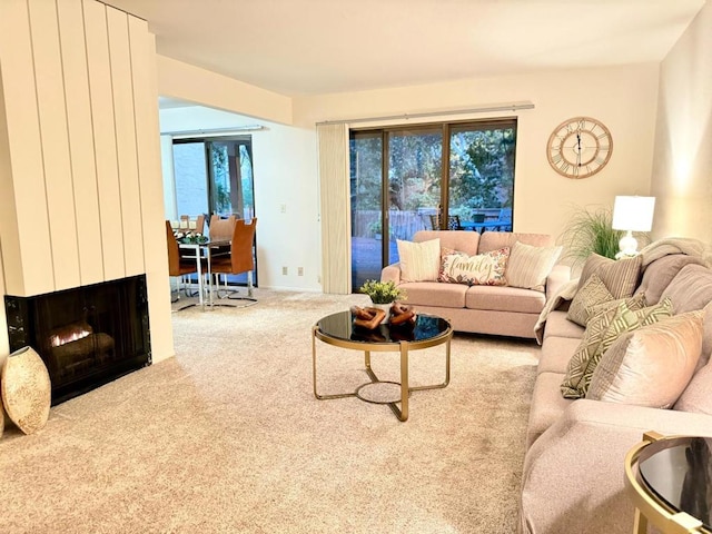 carpeted living room with a large fireplace