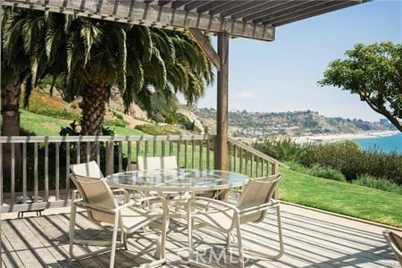 wooden deck with a pergola and a water view