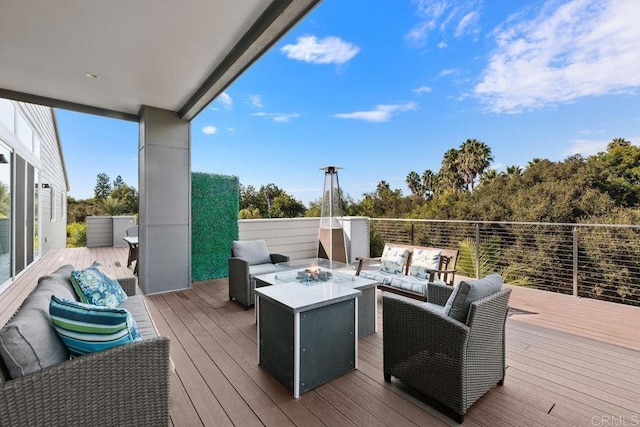 wooden deck with an outdoor living space with a fire pit