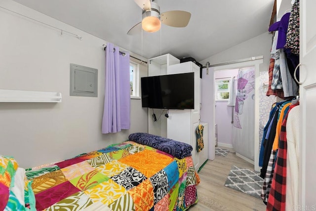 bedroom with ceiling fan, light hardwood / wood-style floors, and lofted ceiling