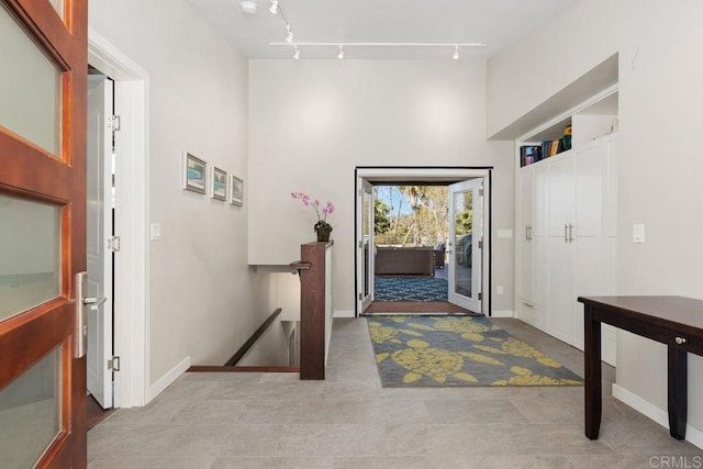 entrance foyer featuring rail lighting and french doors