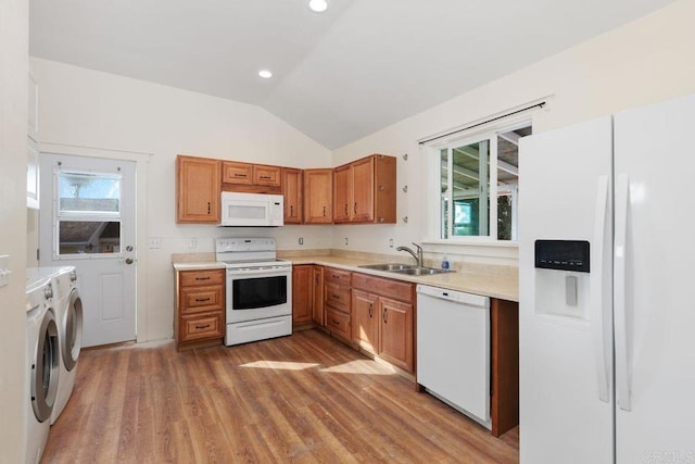 kitchen featuring light hardwood / wood-style floors, white appliances, separate washer and dryer, vaulted ceiling, and sink