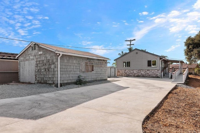 back of property featuring a storage shed