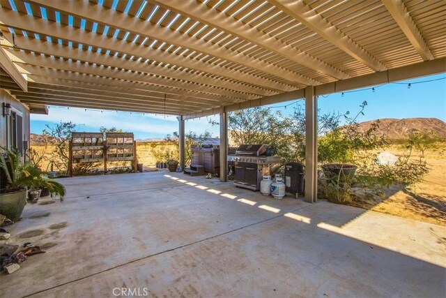 view of patio with a mountain view, a pergola, and grilling area