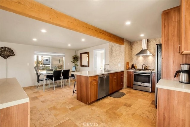 kitchen with kitchen peninsula, a kitchen breakfast bar, stainless steel appliances, wall chimney range hood, and beam ceiling