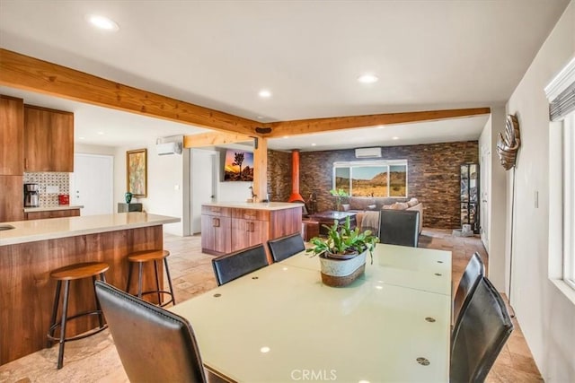 dining space featuring a healthy amount of sunlight and a wall unit AC