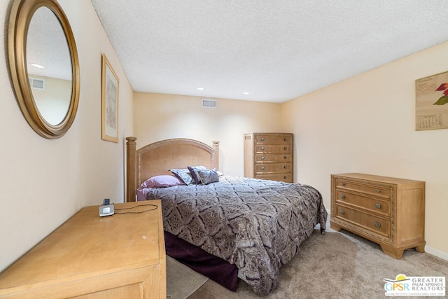 bedroom with light colored carpet and a textured ceiling