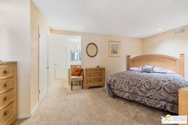 bedroom with light carpet and a textured ceiling