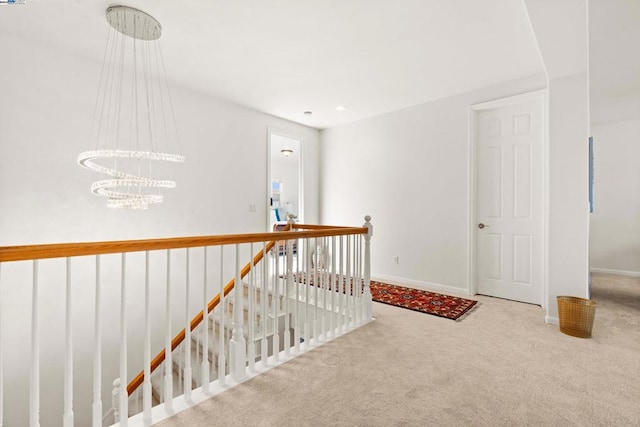 hall with a notable chandelier and carpet