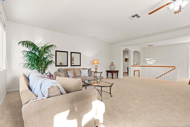 carpeted living room with ceiling fan