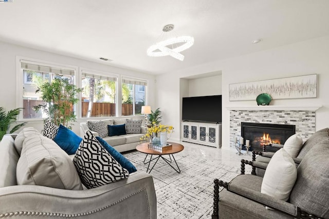 living room with a notable chandelier and a tile fireplace