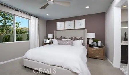 carpeted bedroom featuring connected bathroom and ceiling fan