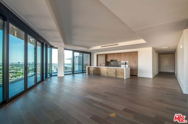 unfurnished living room featuring floor to ceiling windows and dark hardwood / wood-style floors