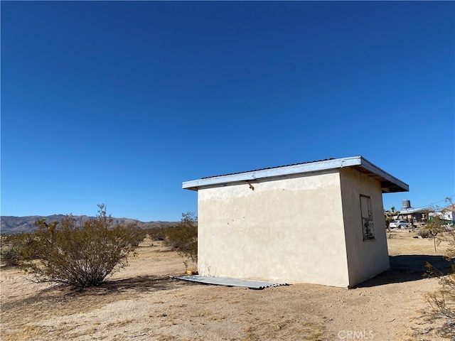 view of side of home with a shed