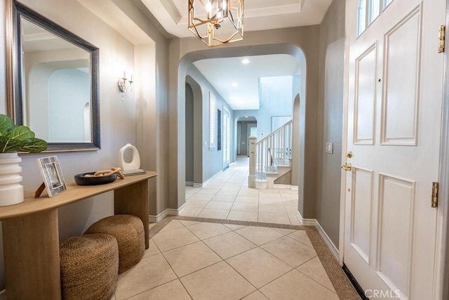 hall featuring light tile patterned floors, plenty of natural light, and a notable chandelier