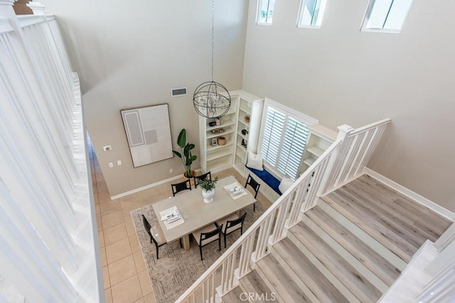 stairway featuring a notable chandelier and wood-type flooring