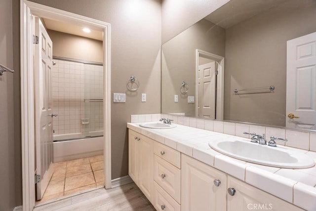 bathroom featuring vanity, hardwood / wood-style flooring, and enclosed tub / shower combo