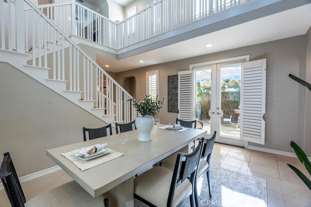 tiled dining space with french doors and a high ceiling