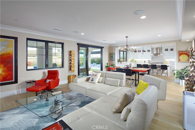 living room with a healthy amount of sunlight, light hardwood / wood-style floors, and an inviting chandelier