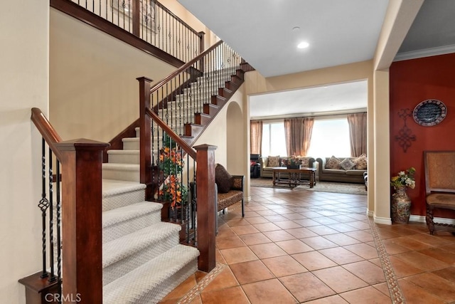 stairway featuring tile patterned flooring and crown molding