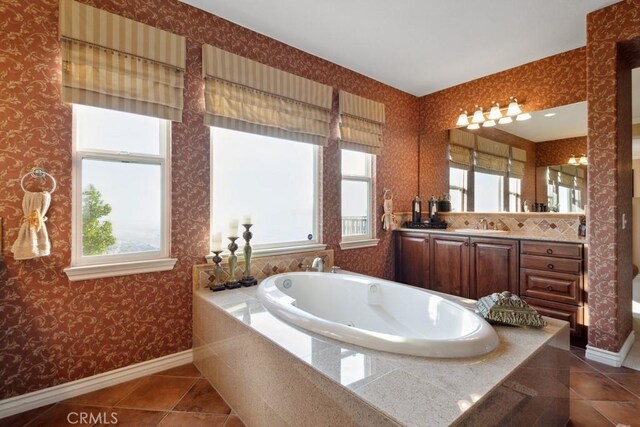 bathroom with vanity, tile patterned floors, a relaxing tiled tub, and a wealth of natural light