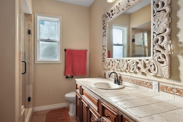 bathroom with toilet, a shower with door, and vanity