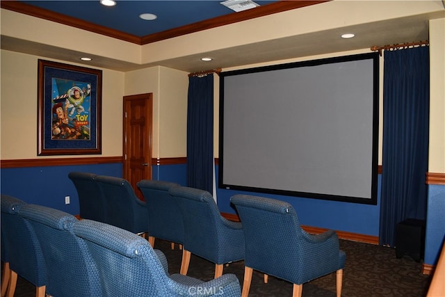 home theater room featuring ornamental molding and carpet