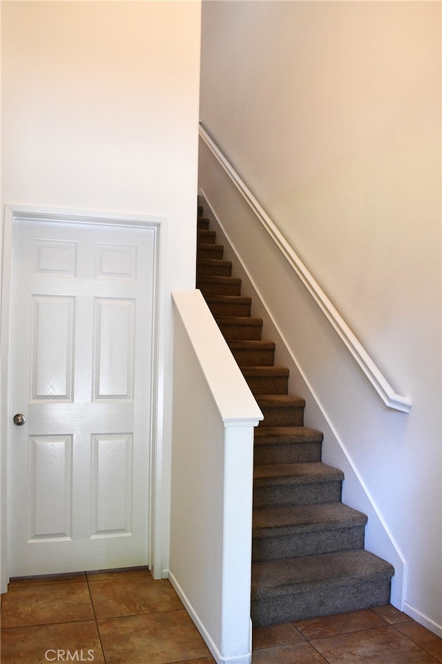 staircase featuring tile patterned flooring