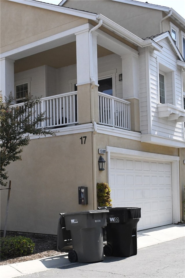 view of property exterior featuring a balcony and a garage