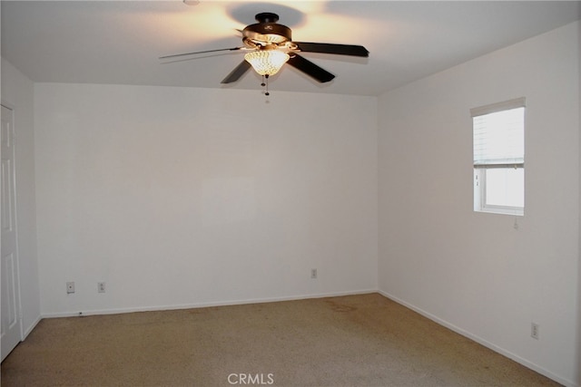 carpeted spare room featuring ceiling fan