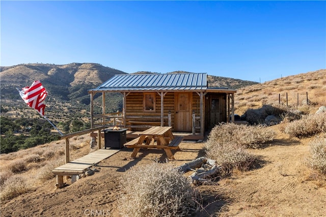 rear view of house featuring a mountain view and a fire pit