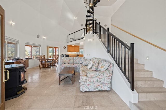 living room with high vaulted ceiling and a wood stove