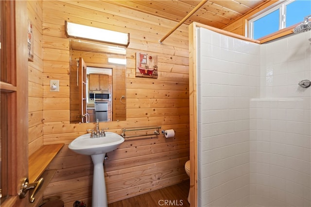 bathroom with walk in shower, wood-type flooring, wood ceiling, wood walls, and toilet