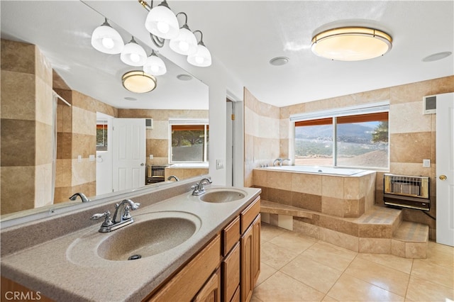 bathroom with tiled bath, heating unit, tile patterned floors, and vanity