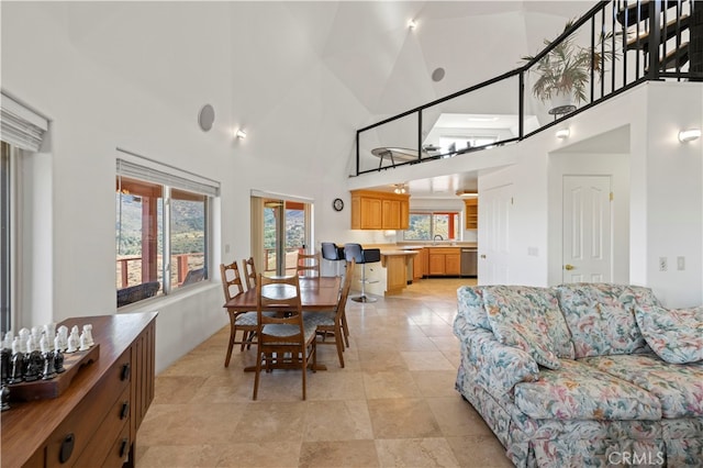 dining area featuring high vaulted ceiling and sink