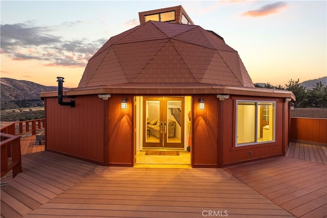 deck at dusk featuring a mountain view